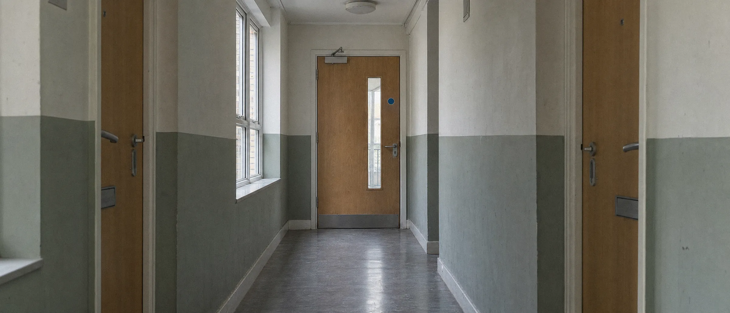 Self-closing fire door in a communal corridor of a block of flats