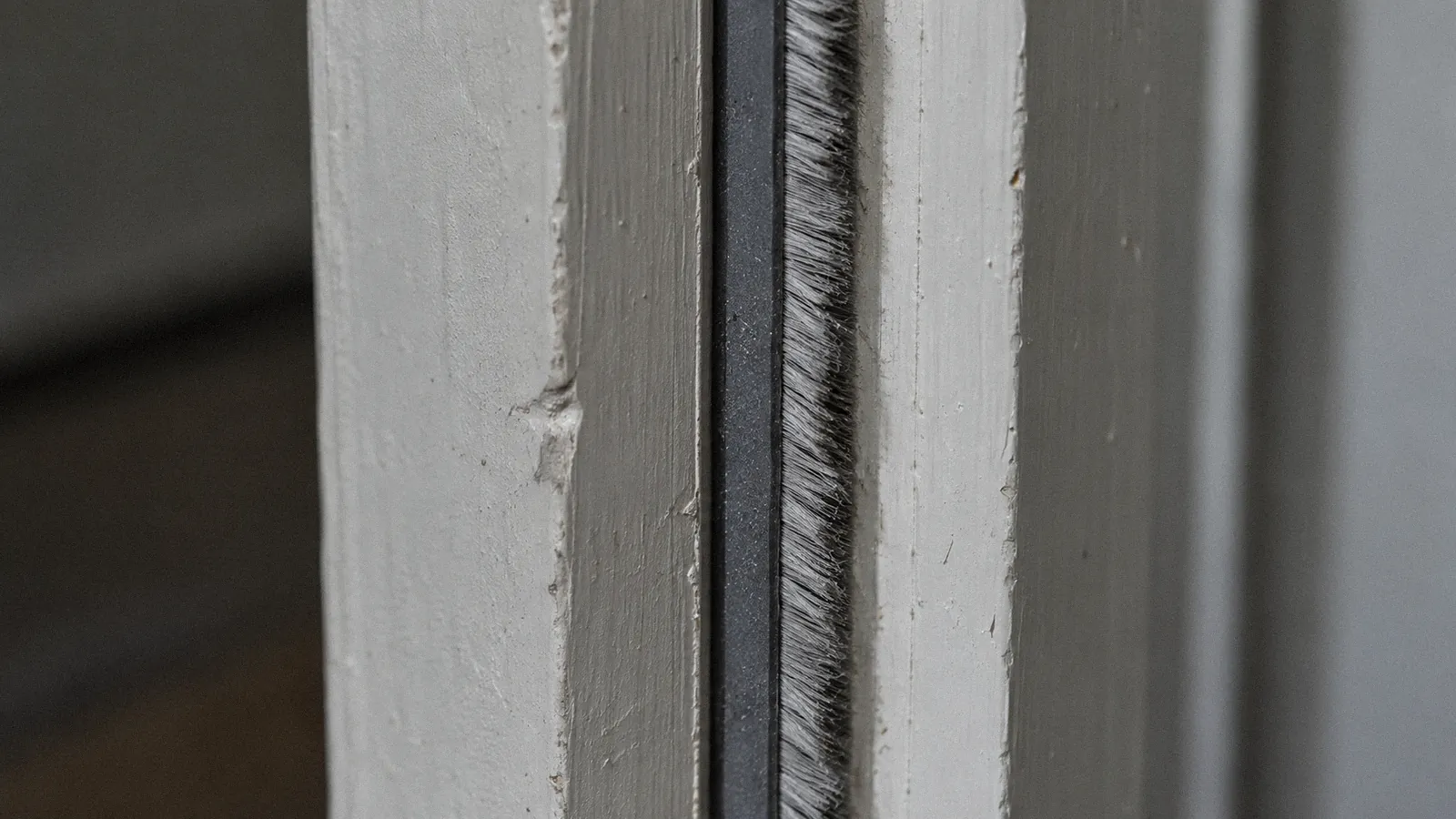 Close-up of an intumescent strip with a brush smoke seal in a fire door frame