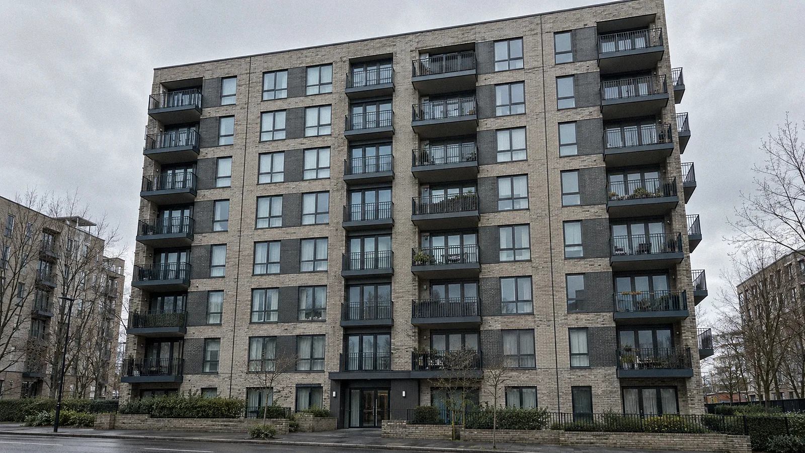 Exterior of a mid-rise UK block of flats showing balconies and external walls